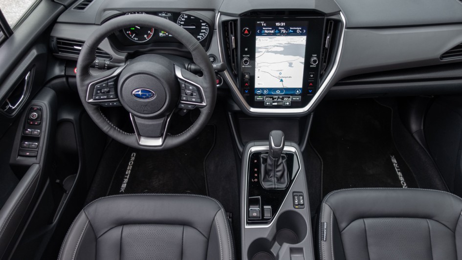 Cockpitfoto durchs geöffnete Schiebedach des Subaru Crosstrek mit schwarzer Lederausstattung