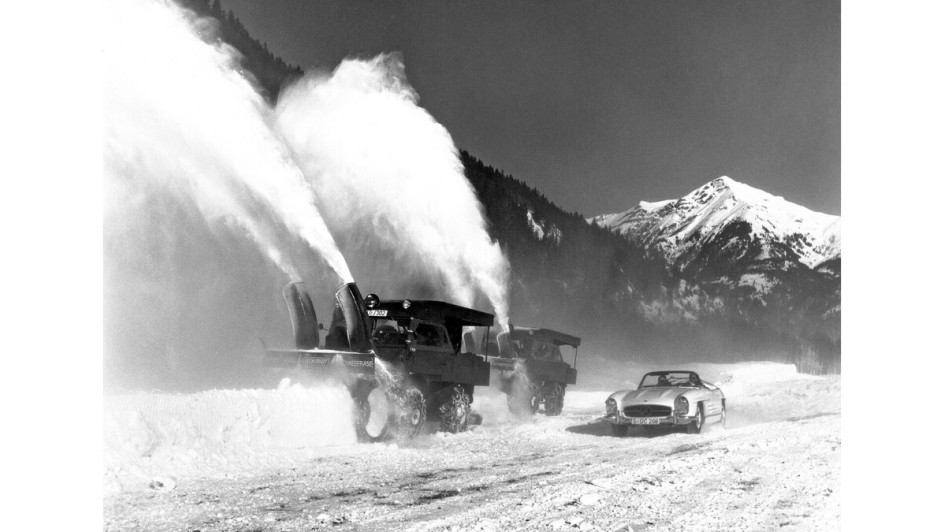 Zwei Mercedes-Benz Unimog der Baureihe 411 mit Schneefräse, angetrieben von einem zusätzlichen Motor auf der Pritsche. Im Vordergrund ein Mercedes-Benz 300 SL Roadster (W 198).