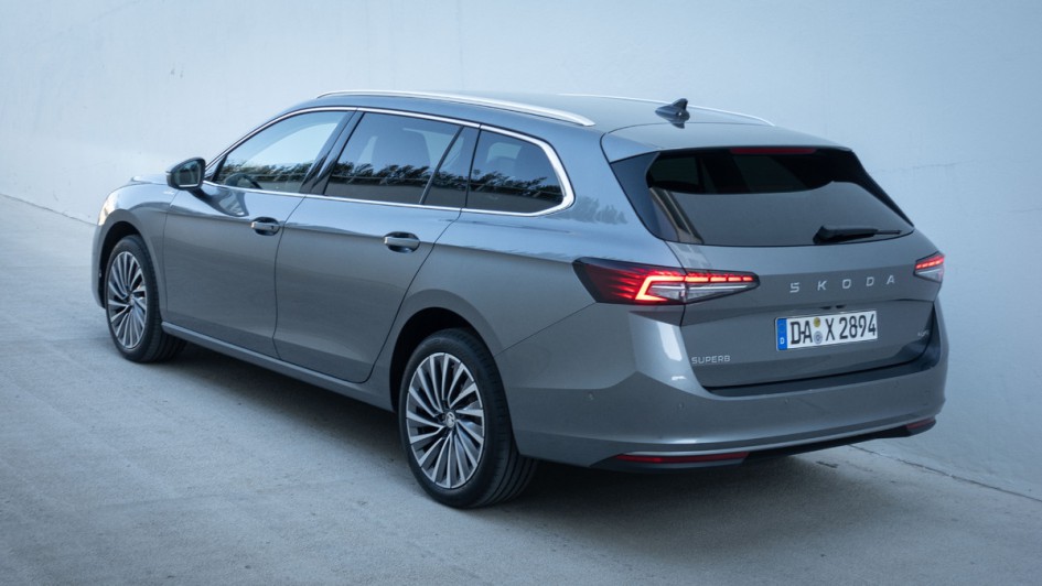 Skoda Superb Combi (2024) schraeg von hinten vor weißer Wand fotografiert