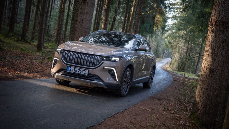 Togg T10X steht mit eingeschaltetem Abblendlicht in einer Waldlichtung