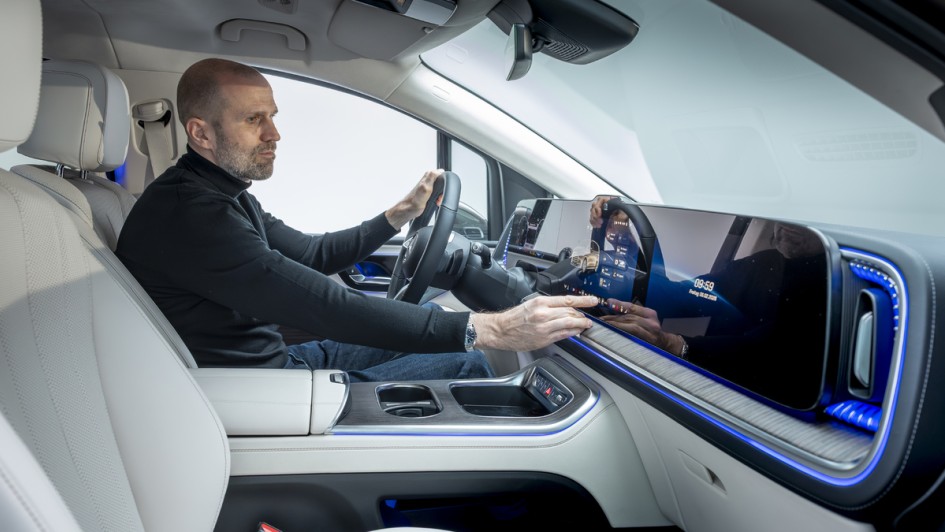 Cockpitfoto des neuen Mercedes VLE mit Mann am Steuer der das Infotainmentsystem bedient