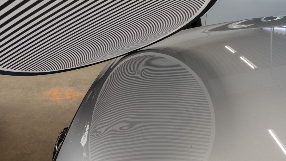 Zebra-Reflektor nennt sich dieses Utensil, um kleinste Dellen in der Karosserie zu erspähen.