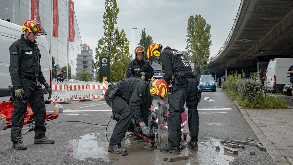 Am frühen Morgen kleben sich sechs Mitglieder des Widerstandskollektiv auf die Straße bei der Donnersbergerbrücke. Eine Aktivistin musste von der Polizei mit der Flex aus den Asphalt geschnitten werden.